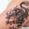 Fresh dragon tattoo design showing intricate linework and shading detail on skin
