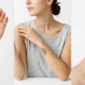 Collection of various small tattoos displayed on different parts of a woman's body with studio lighting