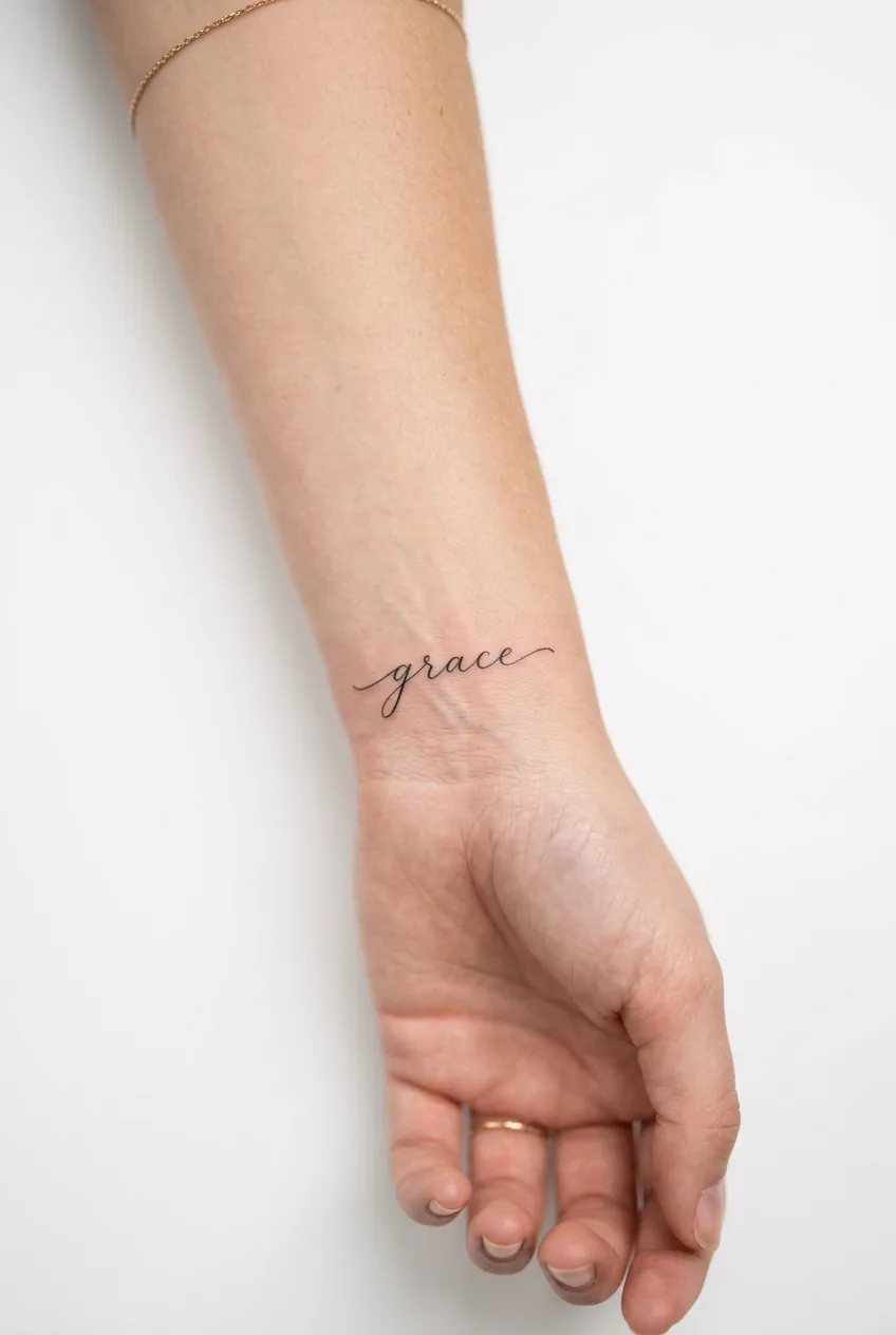 Delicate script tattoo on woman's wrist pulse point with fine lettering detail