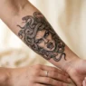 Detailed Medusa tattoo on woman's forearm showing intricate serpent hair and fierce facial expression with dramatic shading