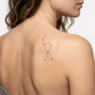 Small constellation tattoo no bigger than a quarter on woman's shoulder blade with fine dotwork detail