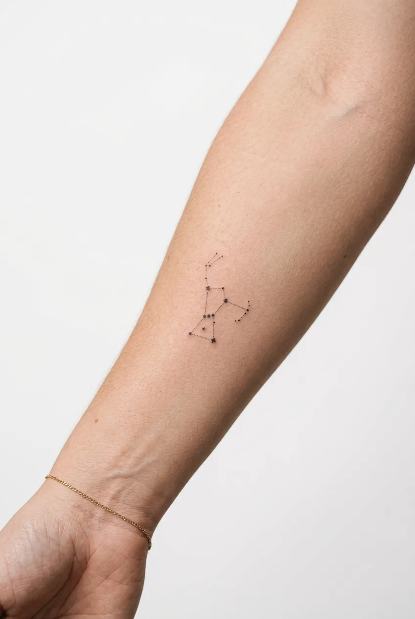 Tiny constellation tattoo on woman's forearm showing delicate dot placement in quarter-sized design